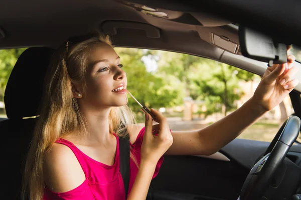 Smiling girl with lip gloss in car — Stock Photo, Image