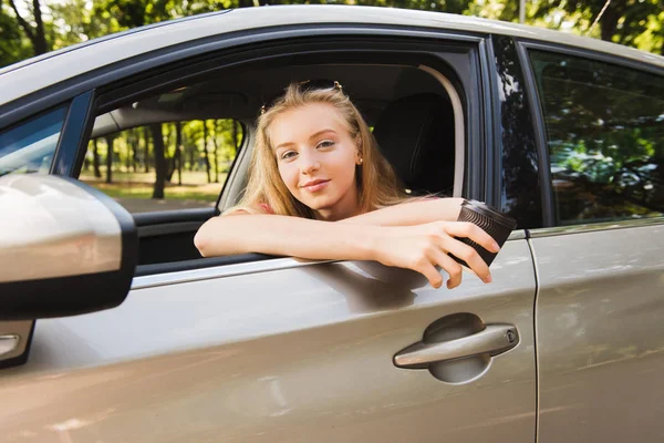 Portrait of girl in car with paper cup — Stock Photo, Image