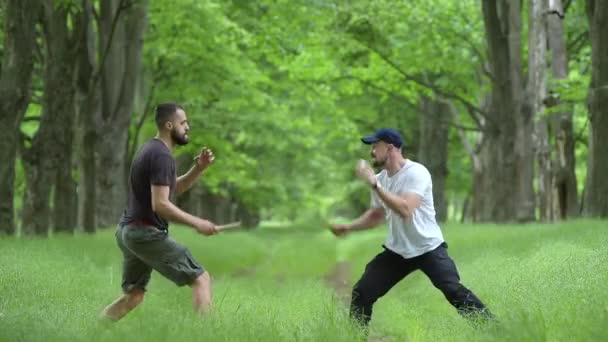 Amigos entrenamiento sparring pelea masculina con cuchillos — Vídeo de stock
