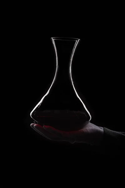 Wine decanting by man in white gloves at black background