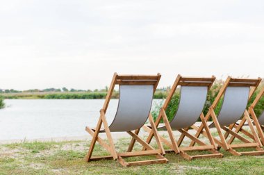 Üç beyaz lüks şezlong suya yakın