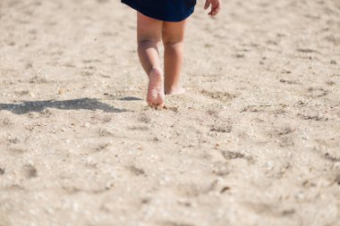 Bebek toddler bacakları yürüyüş kum kapatın.