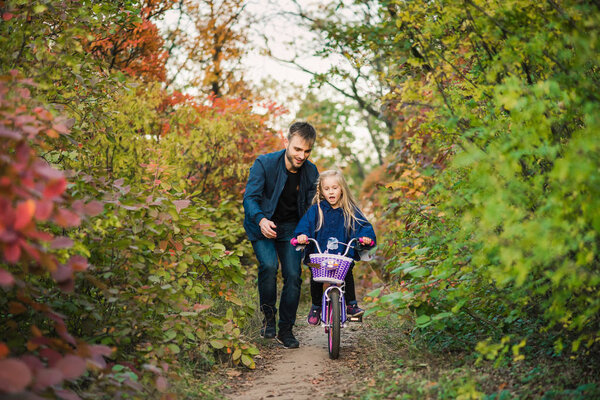 Father teach daughter how to drive bike