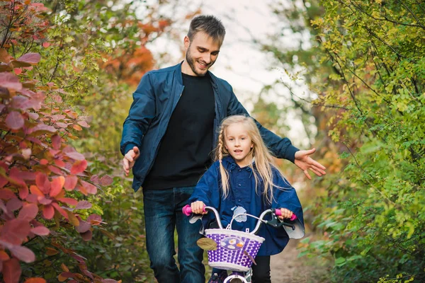 Jeune père enseigner la fille préscolaire à conduire un vélo — Photo