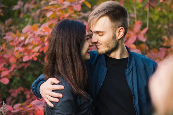 Happy young couple hugging at autumn forest — Stock Photo, Image