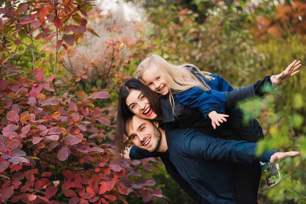 Happy young family smile in autumn park — Stock Photo, Image