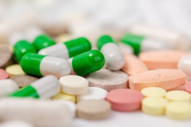 Renkli ilaç ve ilaç. Sarı, pembe, beyaz, yığın yakın çekim yeşil tablet, kapsül. Hapları yığını.