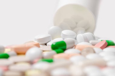 Beyaz arka plan üzerinde metin için yer Serves hapı şişesiyle dışarı dökülmesini hapları. Sağlık kavramı. Plastik şişe dağınık takviyeleri.
