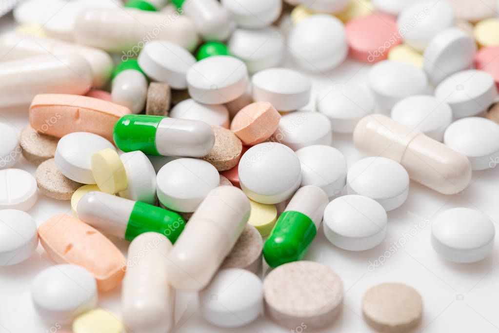Colorful medication and pills. Close-up of pile of yellow, green, pink tablets, capsule. Heap of pills. Pills and tablets as Medical background. Top view.