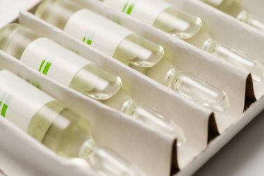 Dört tıbbi ampul veya tüpleri veya ampul bir kutu ilaç ile yakın çekim.