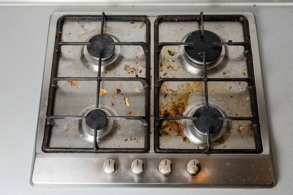 Dirty gas stove in the kitchen, top view. Gas stove with food remnants.