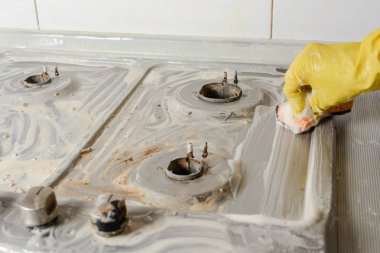 Gaz sobası yıkama sarı eldiven ver. Bir gaz Temizleme mutfak eşyaları, ev kavramları ve temizlik ile soba. Bahar temiz temiz-out mutfak gaz sobası.
