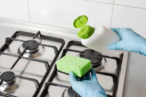 Pour washing detergent from bottle to green sponge