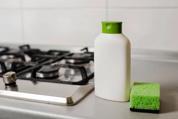 Produto de limpeza em garrafa de plástico no fogão a gás . — Fotografia de Stock