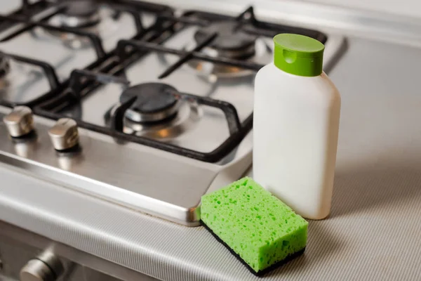 Produto detergente de limpeza e esponja no fogão a gás — Fotografia de Stock