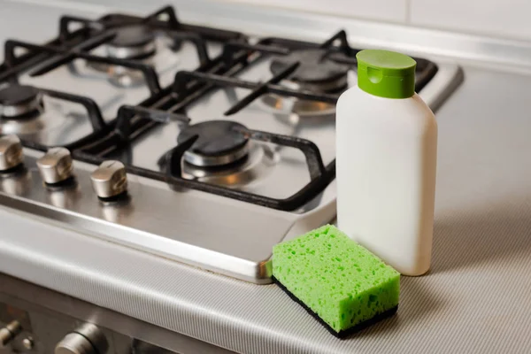 Produto detergente de limpeza e esponja no fogão a gás — Fotografia de Stock