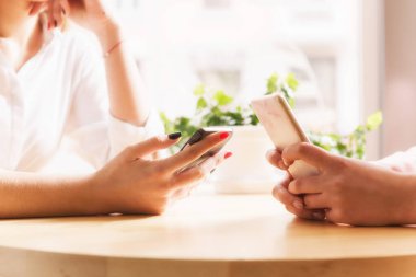 Akıllı telefonlar yakın çekim Cafe ile eller.