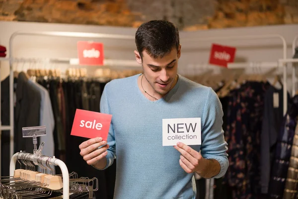 Joven con venta roja y nuevas etiquetas blancas . — Foto de Stock