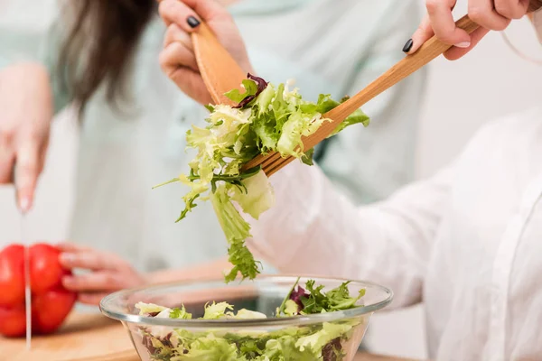 Dos chicas jóvenes cocinando ensalada saludable juntas — Foto de Stock