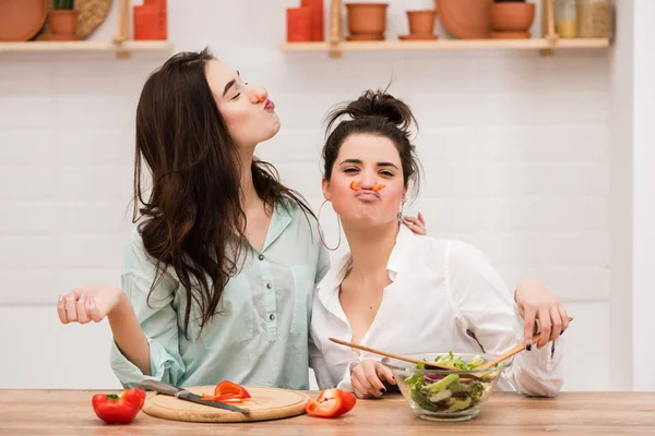 Two women have fun with red pepper as mustache — Stock Photo, Image