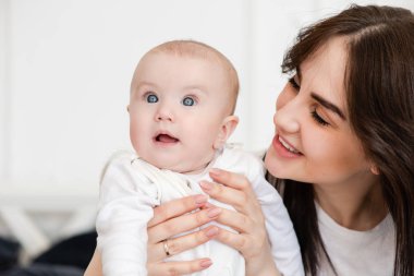 Genç gülümseyen anne çocuğa bakıyor.