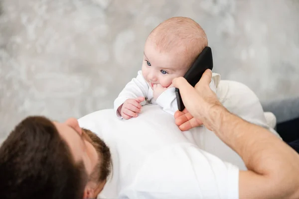 Padre puso el teléfono a la niña oreja — Foto de Stock