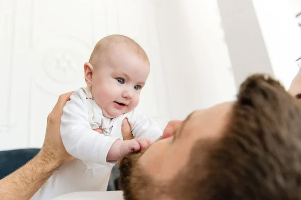 Joven padre sostener y mirar al bebé — Foto de Stock