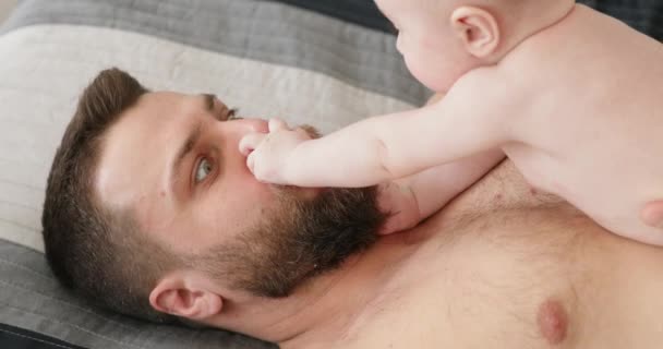 Vater liegt mit Baby auf der Brust zu Hause — Stockvideo