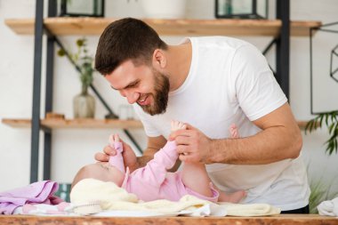 Young man play with laying baby girl