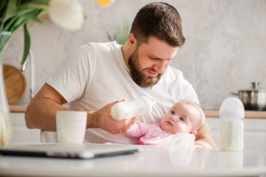 Bir şişe de formül ile yenidoğan besleme Adam.