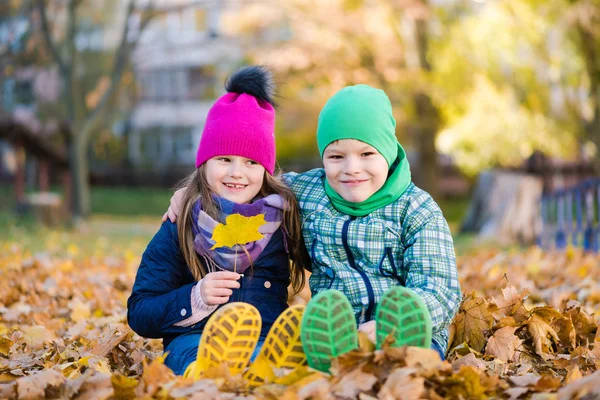 가을 공원에서 산책하는 동안 소년과 소녀 앉아 — 스톡 사진