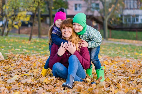 Madre con dos hijos en otoño al aire libre — Foto de Stock