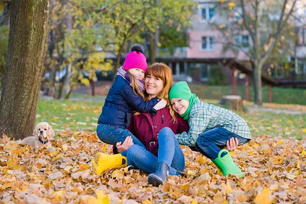 Mamma med två barn på hösten utomhus — Stockfoto