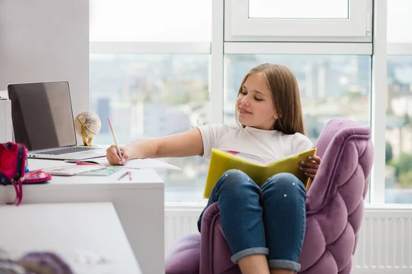 Chica hacer la tarea de la escuela con lápiz y libro — Foto de Stock