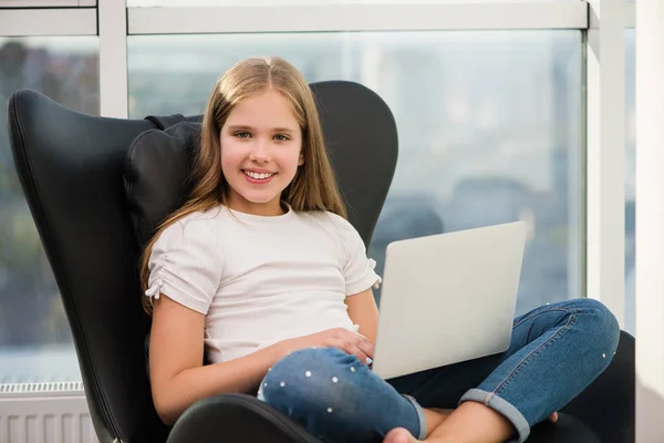 Retrato de la escuela chica sonriente sentarse con el ordenador portátil — Foto de Stock