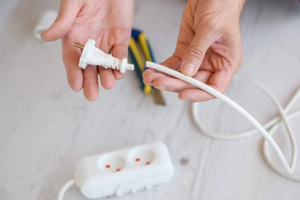 Enchufe eléctrico de extensión rota en manos masculinas — Foto de Stock