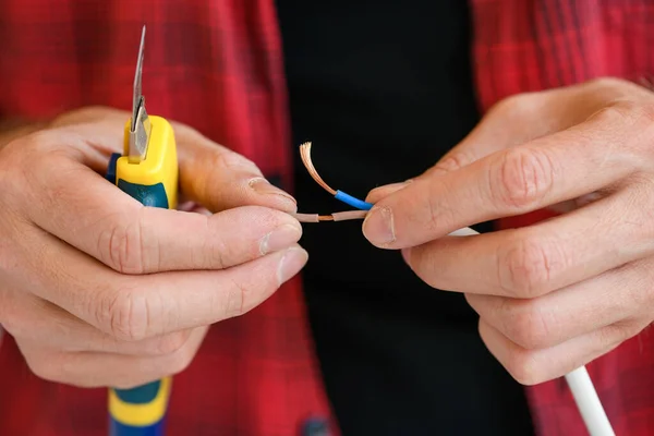 Manos masculinas con cuchillo y cables eléctricos — Foto de Stock