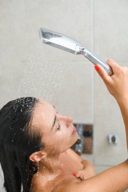 Genç bir kadın duş alır, siyah saçlarını muslukla yıkar ve beyaz fayansların arkasında güzel yüzlere ve ıslak tenlere su damlatır..