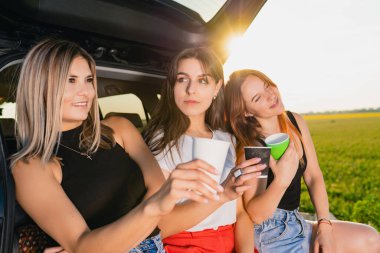 Gülümseyen üç kadın yolcunun yolculukları kutlu olsun. Aracınızda dinlenin. Kahve fincanlarıyla birlikte..