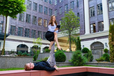 Kızla akroyoga pozisyonu, erkek ayakları üzerinde oturup denge kurmak ve tablet ekran, spor ve iş konsepti, ortaklık ve ağa bakmak