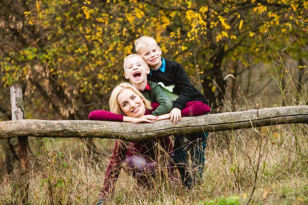 Blond Mor Och Tonåring Tvillingbröder Kramas Och Poserar Nära Trästockar — Stockfoto