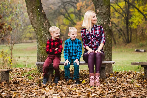 Vacker Blond Familj Med Mor Och Tvillingbröder Sitter Träbänk Höstparken — Stockfoto
