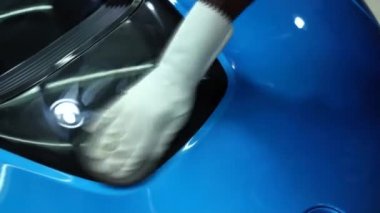Bir araba garajında bir profesyonel tarafından elleri ile lüks bir araba kaputu Parlatma