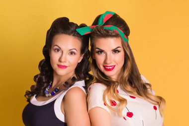 İki güzel kadın elbise poz sarı Studio, toplu iğne stili