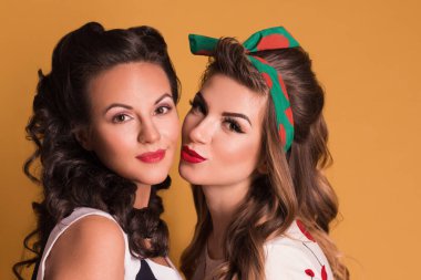 İki güzel kadın elbise poz turuncu Studio, toplu iğne stili