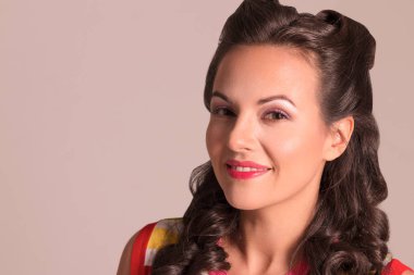 Saç modeli ile esmer güzel ve gülümsüyor stüdyo, pin-up tarzı, yakın çekim portre oluşturuyor