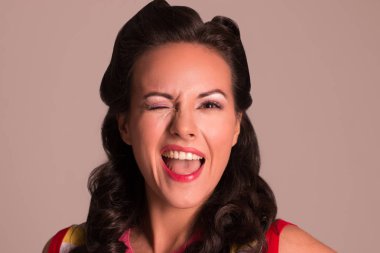 Stüdyo, pin-up tarzı, yakın çekim portre saç modeli göz kırpıyor ile güzel esmer