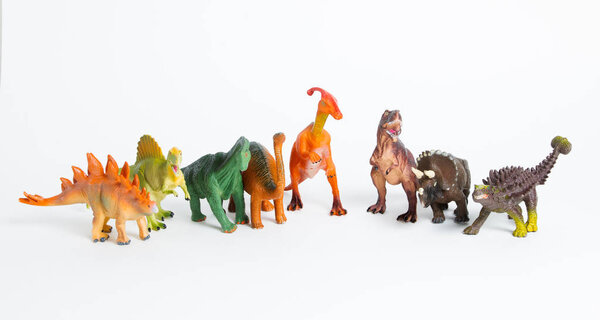 Eight colored different models of dinosaurs on white, children toys