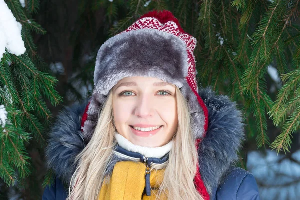 Genç ve güzel kadın şapkalı yakınındaki yeşil çam ağacı Kışın açık durumda