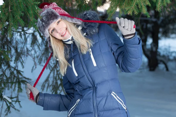 Yeşil çam ağacı kış günü açık yakınındaki kulak-flep şapkalı güzel kız poz veriyor